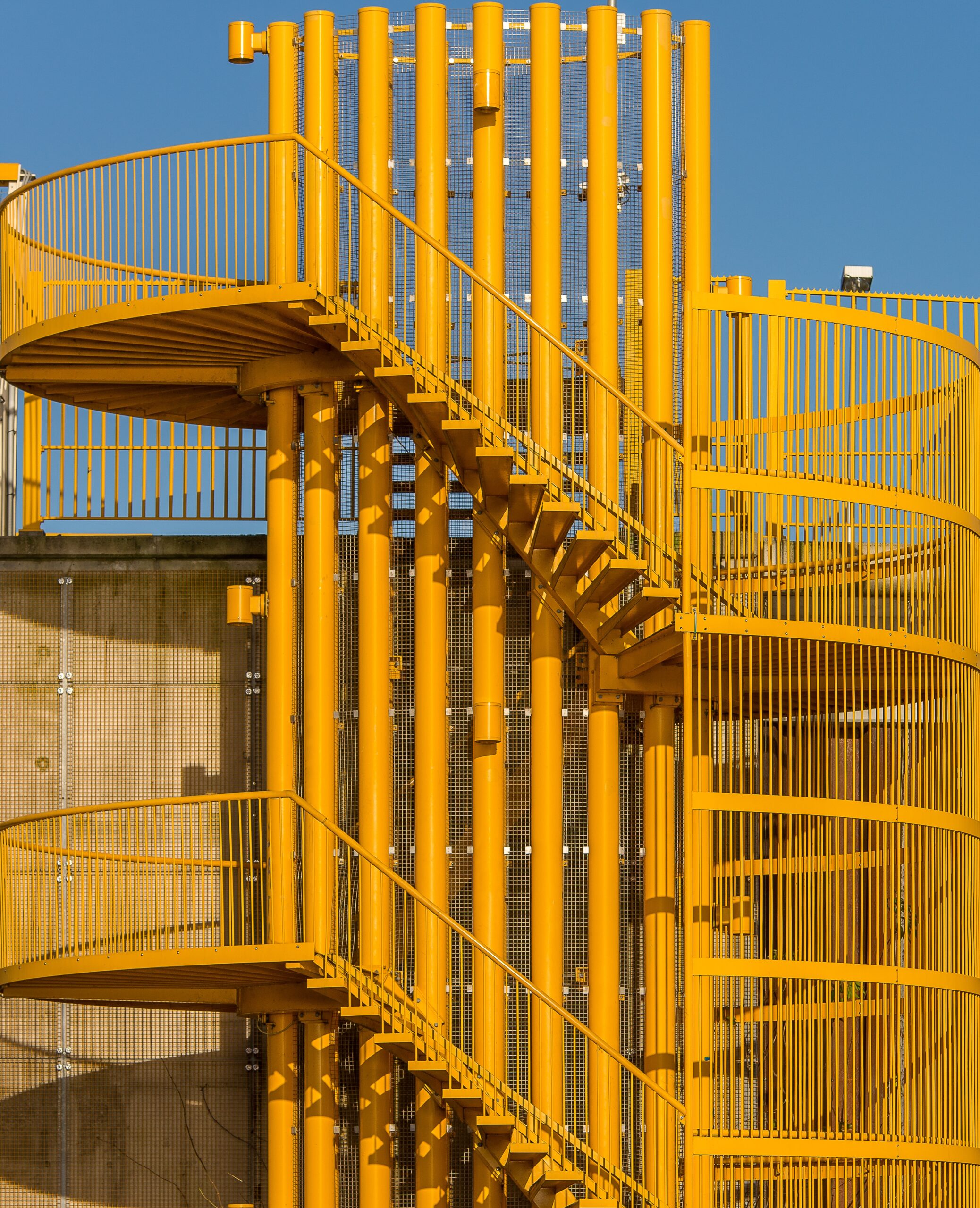 A vertical shot of bright yellow stairs up the wall at daytime